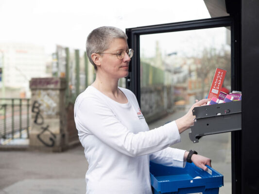 Apothekerin legt Medikamente in ein Abholfach.